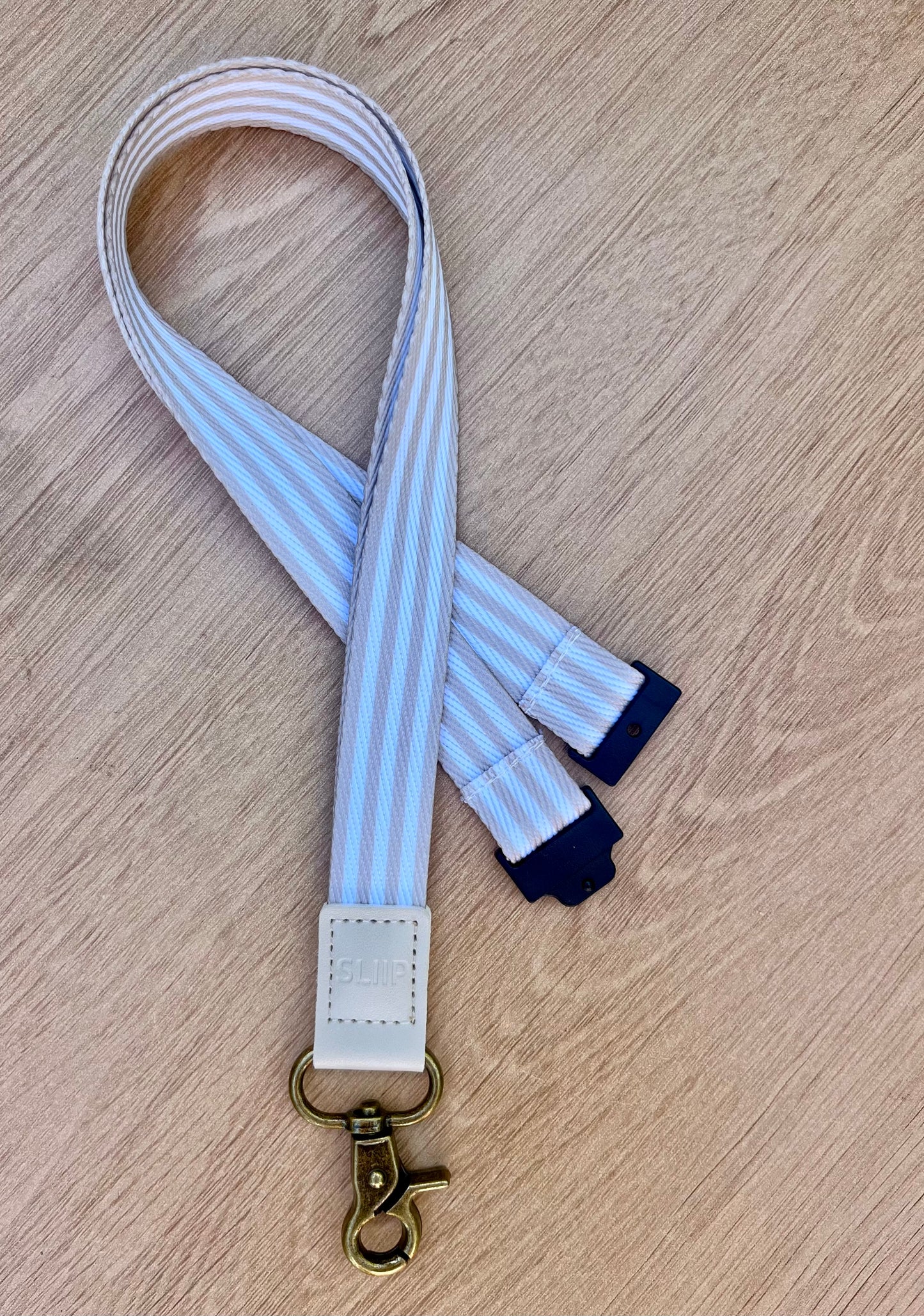 a striped beige and white lanyard with break away safety clip