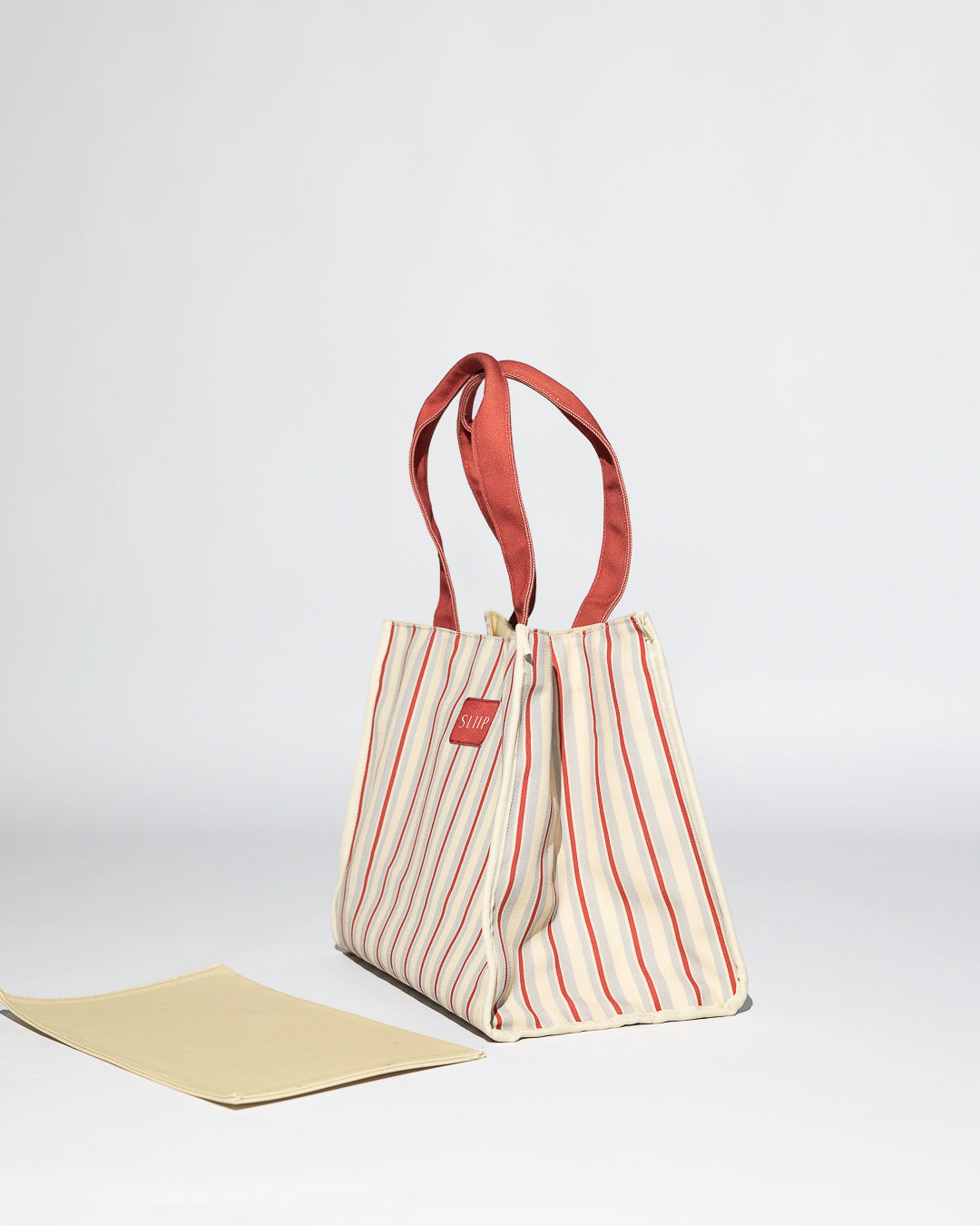 side view of red, blue and beige versa bag, tote bag, with base out, casual mode, structure 