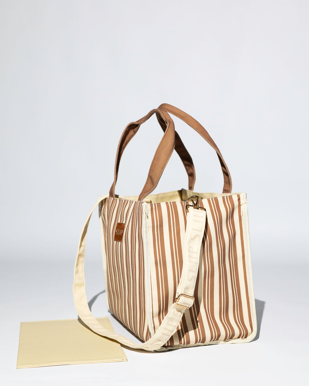 brown and beige striped tote bag with brown handles and branded shoulder strap